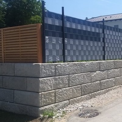 Betonmauer mit kombinierter Sichtschutzlösung aus Holz und blickdichtem Zaun