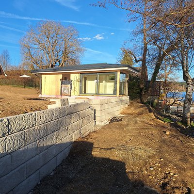 Terrassierung mit Betonblöcken zur Stabilisierung eines Hanggrundstücks am Wasser