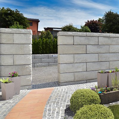 Pflegeleichte Betonmauer mit dekorativem Durchgang – Sichtschutz und Zugang in einem