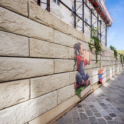 Beton-Stützwand mit Dekoration als temporäre Bauabschirmung im Stadtzentrum