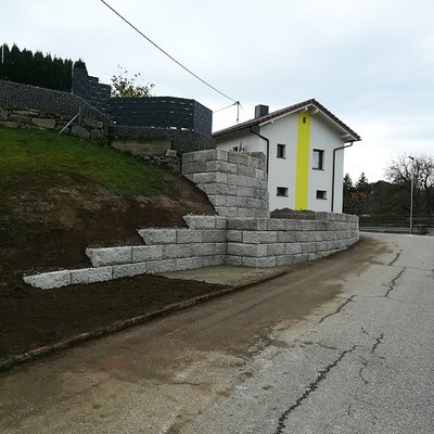 Stabile Betonstützmauer sichert steilen Gartenhang – ideal zur dauerhaften Hangbefestigung am Haus