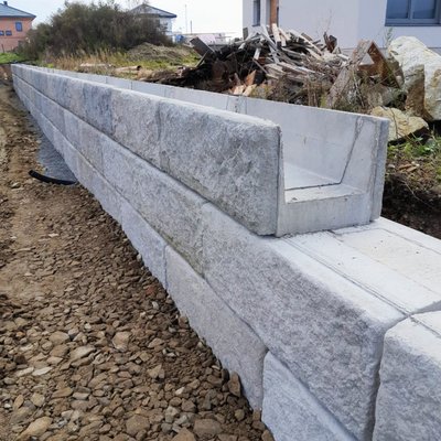 Stützwand mit U-Trog und Natursteinstruktur – technische Lösung für flexible Geländeabschlüsse