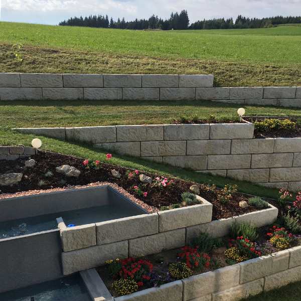 Mehrstufige Gartenlösung aus Beton – ideal zur Hangbefestigung mit Blumenbeet und Beleuchtung