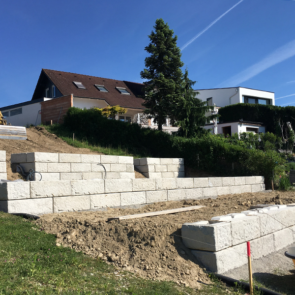 Terrassierte Stützwand mit klarer Linienführung – schafft nutzbaren Gartenraum am Hang